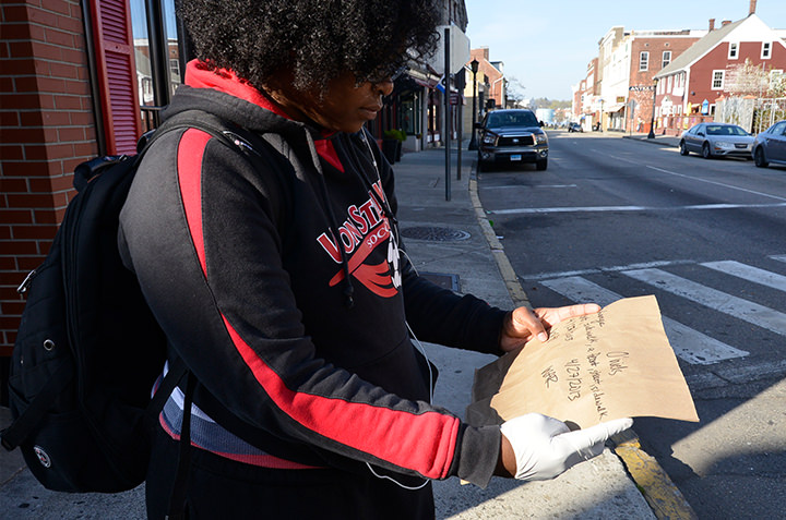 Wynndee Reese '13 examines an abandoned cardboard sign while documenting discarded ephemera on the streets of New London as part of collaborative research in Anthropology 482 (Archaeology of the Contemporary).