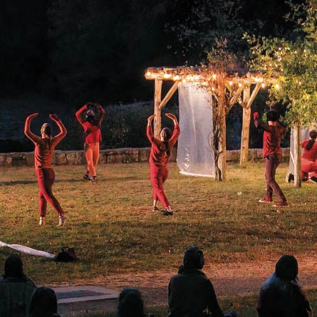 Image of masked dancers in the arboretum at night