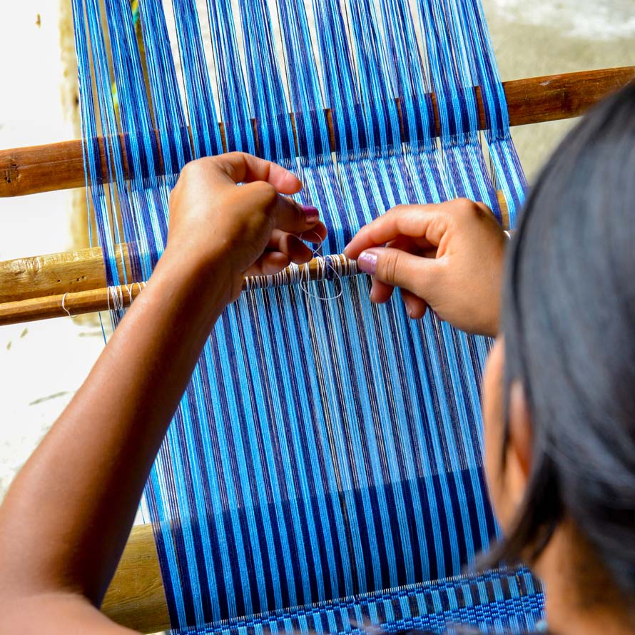 Close-up of hands weaving at loom