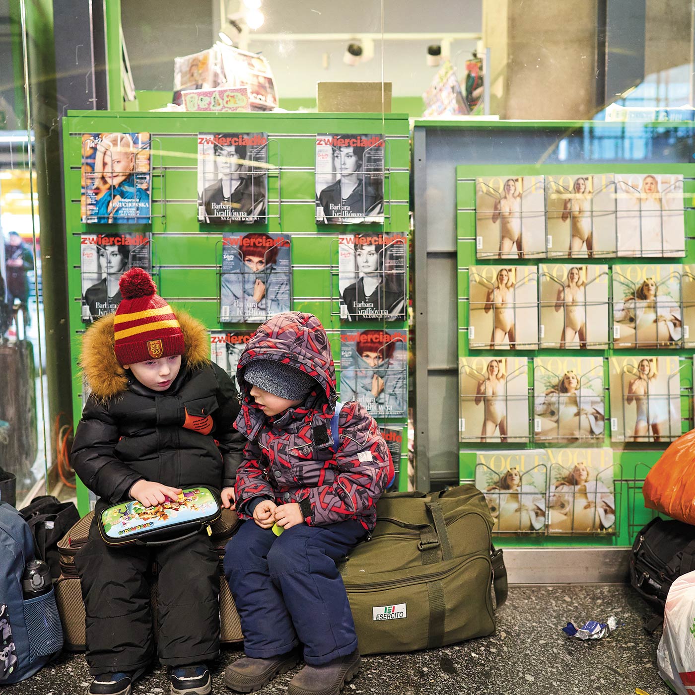 Image of young boys sitting in front of news rack