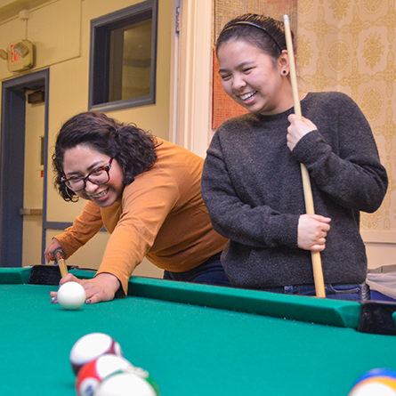 Two students playing pool in the Smith Game Room. 