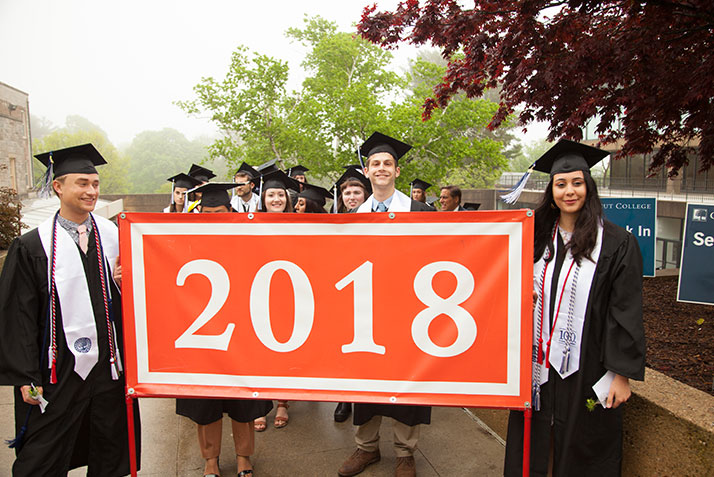 Graduates hold the Class Banner at Commencement 2018