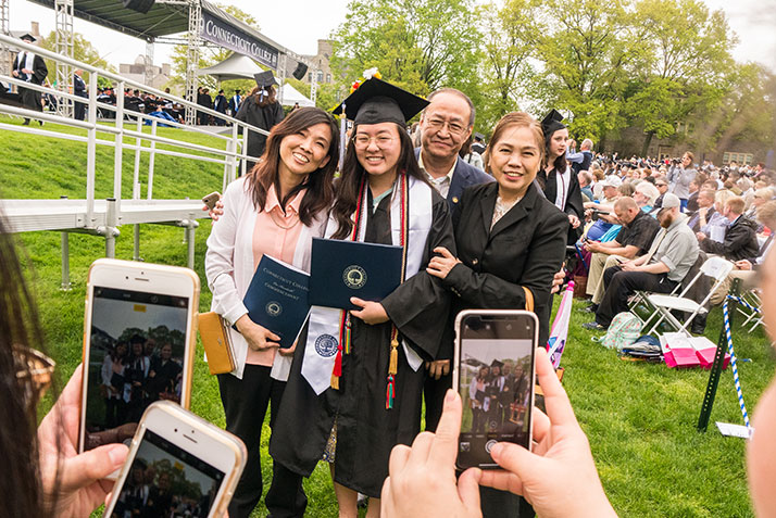 A graduate poses with her family at Commencement 2018
