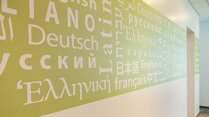 A wall with a lime green stripe and words written in different languages