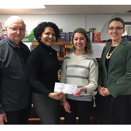 Chelsea Groton's Christina Nocito (second from left), Sarah Harris (second from right), and Professor Joyce Bennett (far right) present a check to New London Area Food Coalition Treasurer Bob Lavoie (far left)