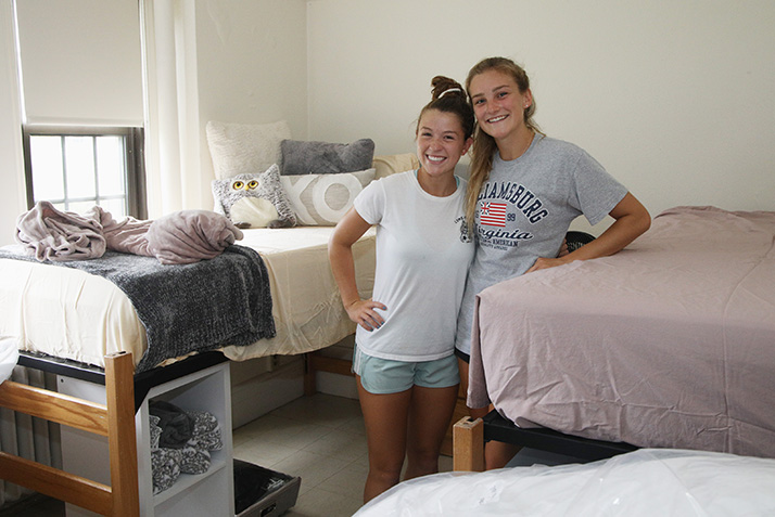 New roommates pose together in their room.