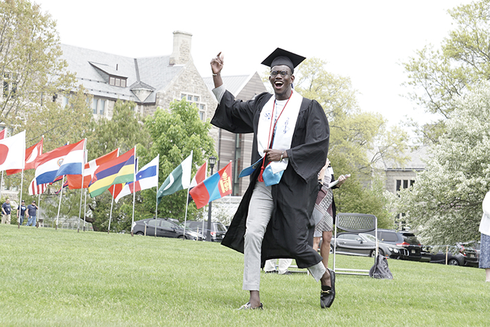 A graduate celebrates as he receives his diploma.