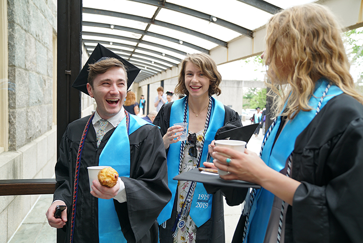 Students share a laugh before Commencement. 