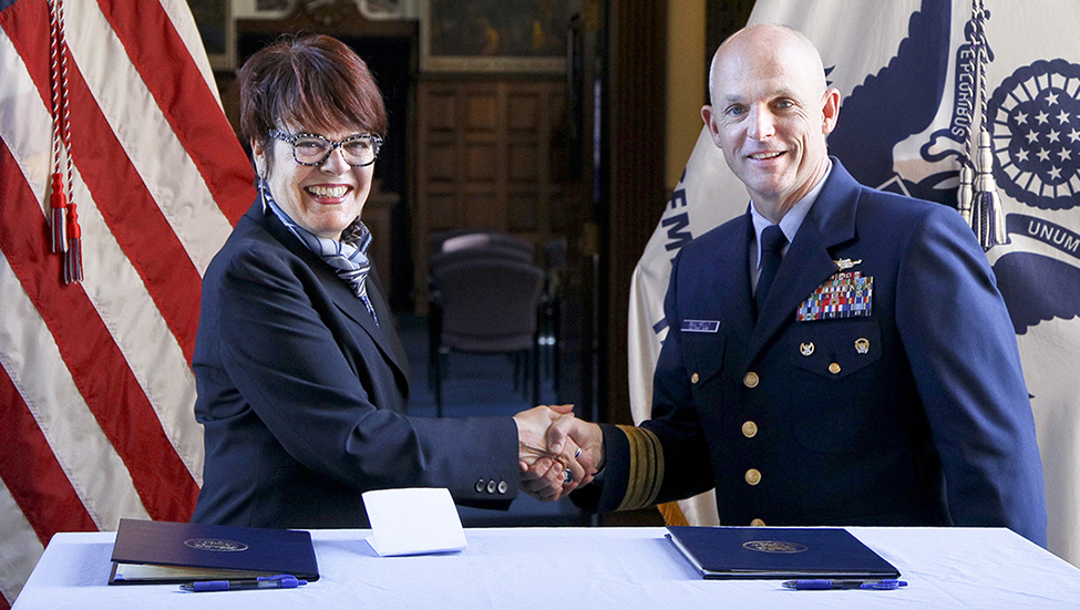 Connecticut College President Katherine Bergeron, left, and the superintendent of the U.S. Coast Guard Academy, Rear Admiral William G. Kelly, shake hands after signing the new Memorandum of Agreement.