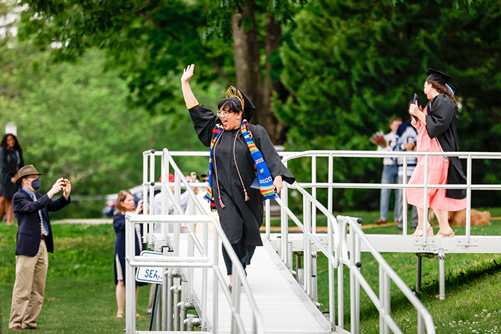 A graduate waves to the crowd.