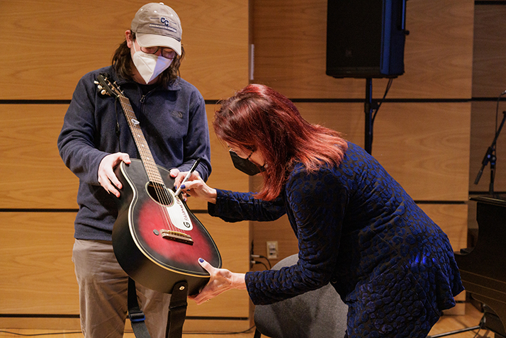 Rosanne Cash autographs a student's guitar.