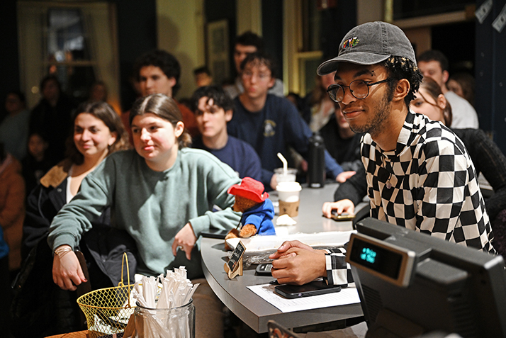 students watch a band concert in a crowded coffeehouse.
