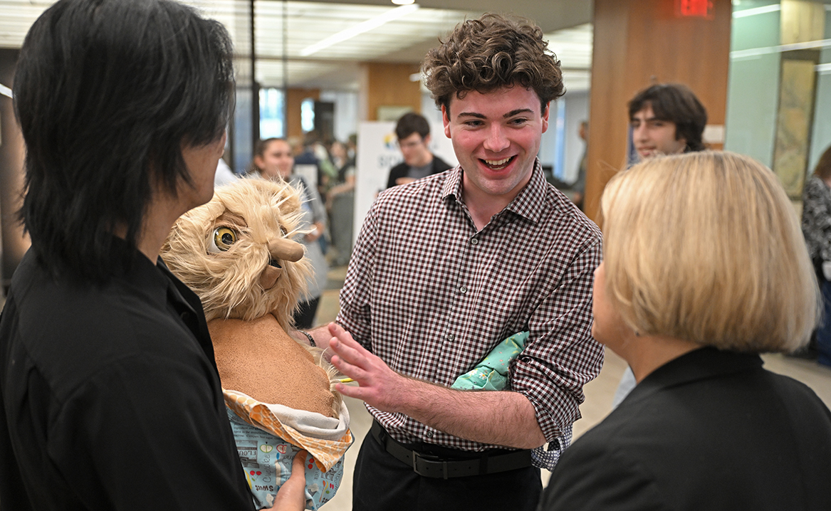 Timothy Friend '25 shows off his animatronic puppet at the All-College Symposium.